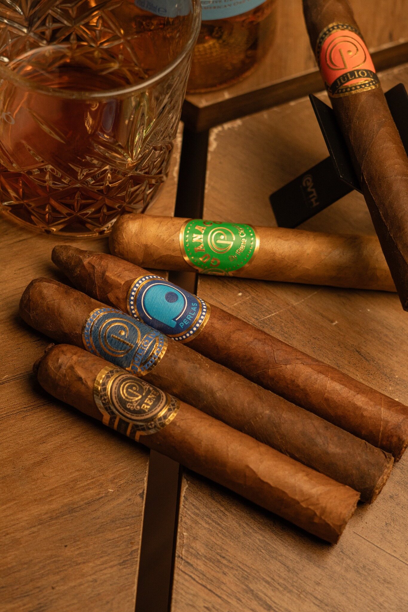 Colección de vitolas René Cigars junto a una copa
