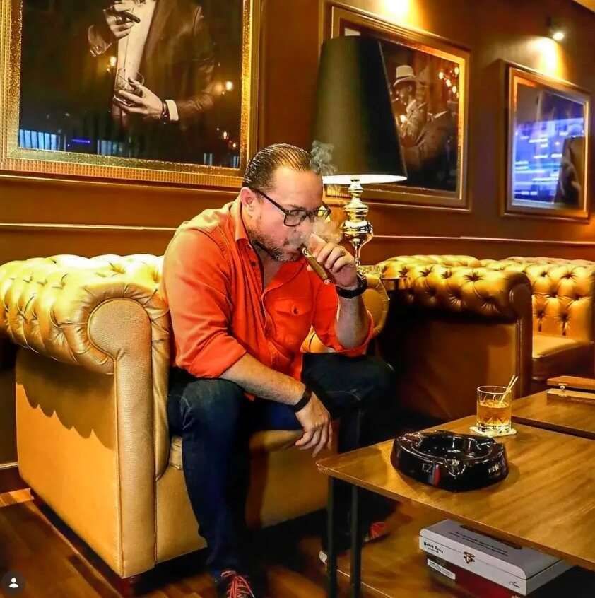Julio César Fuentes | Fundador de René Cigars Julio César Fuentes, fundador y CEO de René Cigars, disfrutando un cigarro premium dominicano en un cigar lounge